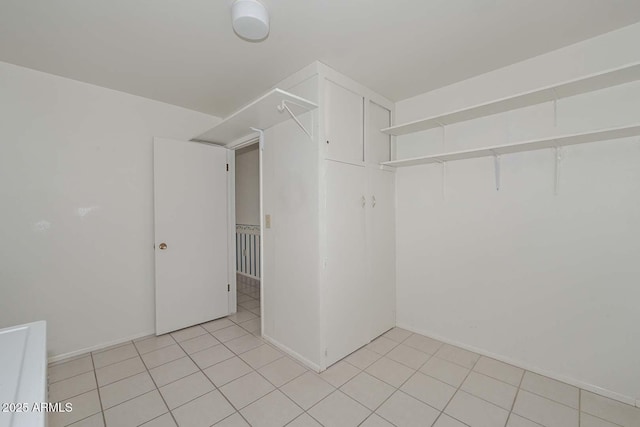 walk in closet with light tile patterned floors