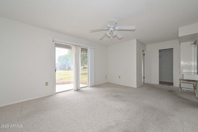 carpeted empty room with a textured ceiling and a ceiling fan