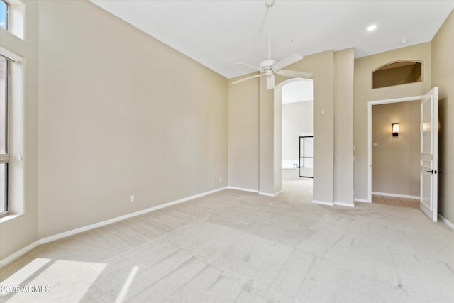 16615 N 109th Pl, Scottsdale, AZ 85255 - empty room featuring arched walkways, baseboards, light colored carpet, and ceiling fan