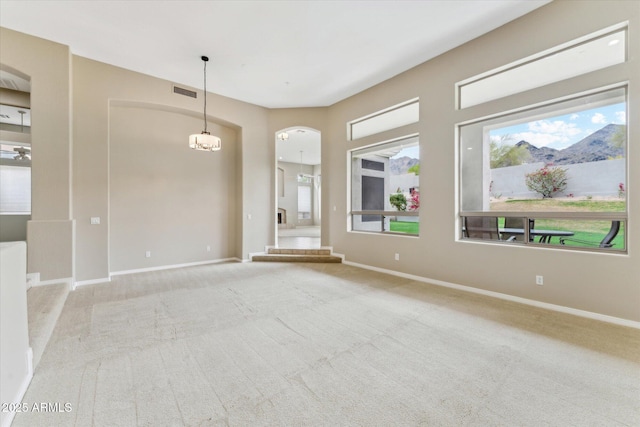16615 N 109th Pl, Scottsdale, AZ 85255 - spare room featuring arched walkways, a healthy amount of sunlight, carpet flooring, and baseboards