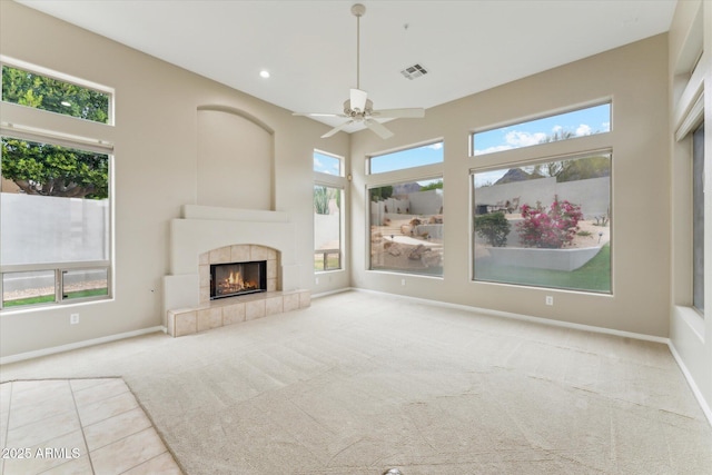 16615 N 109th Pl, Scottsdale, AZ 85255 - unfurnished living room featuring a ceiling fan, carpet floors, a tiled fireplace, baseboards, and visible vents