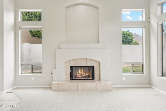 16615 N 109th Pl, Scottsdale, AZ 85255 - unfurnished living room featuring carpet floors, a tile fireplace, and baseboards