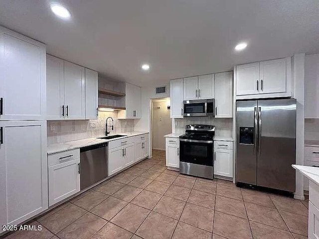 kitchen featuring a sink, stainless steel appliances, visible vents, and light countertops