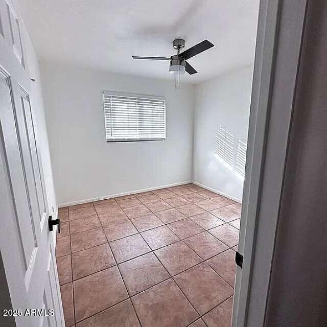 unfurnished bedroom with baseboards, ceiling fan, and tile patterned flooring