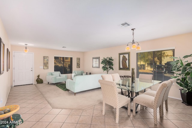 dining area with light tile patterned flooring and an inviting chandelier