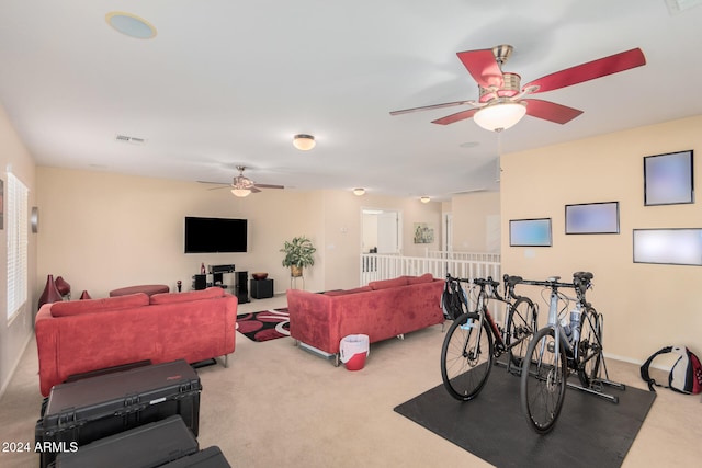 exercise room with ceiling fan and light colored carpet