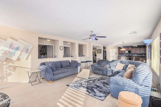 carpeted living room with ceiling fan