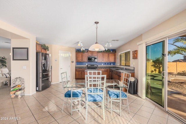 kitchen with sink, decorative light fixtures, light tile patterned floors, and stainless steel appliances