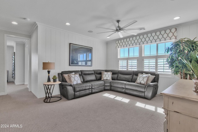 living room with crown molding, wooden walls, ceiling fan, and light colored carpet