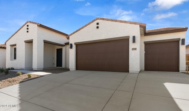 mediterranean / spanish-style home featuring stucco siding, driveway, a garage, and a tiled roof