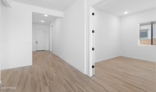 hallway featuring baseboards, light wood-style floors, and recessed lighting