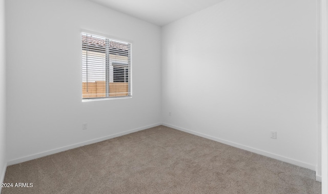unfurnished room featuring baseboards and carpet