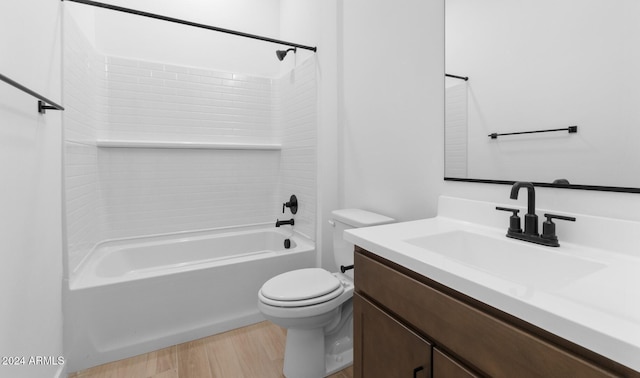bathroom with wood finished floors, toilet, vanity, and washtub / shower combination