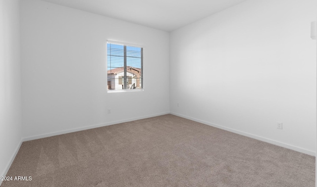 carpeted empty room featuring baseboards