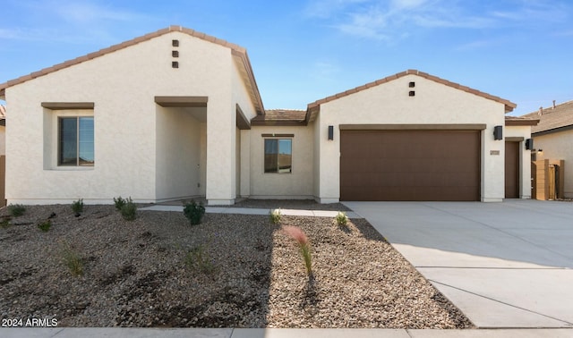 mediterranean / spanish-style house with driveway, stucco siding, a tile roof, and a garage