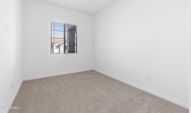 carpeted empty room featuring baseboards