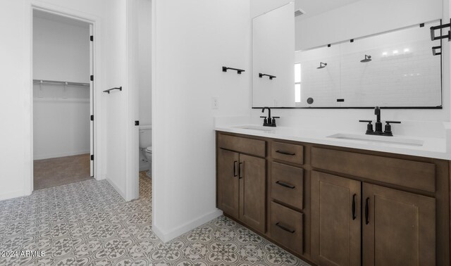 bathroom featuring toilet, a shower, and vanity