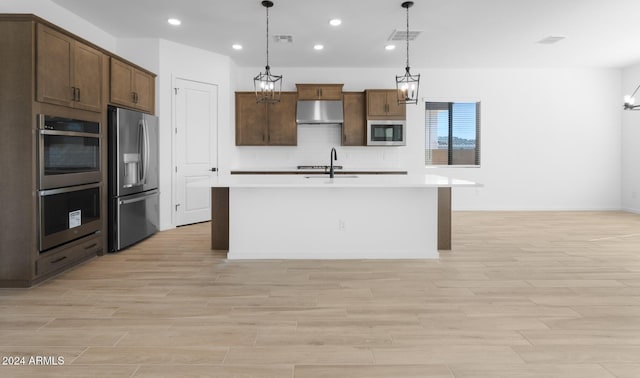 kitchen featuring a notable chandelier, a sink, stainless steel appliances, visible vents, and decorative backsplash