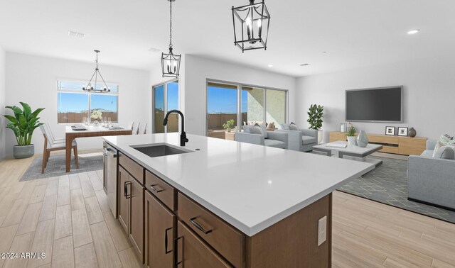 living room with sink, a notable chandelier, and light hardwood / wood-style floors