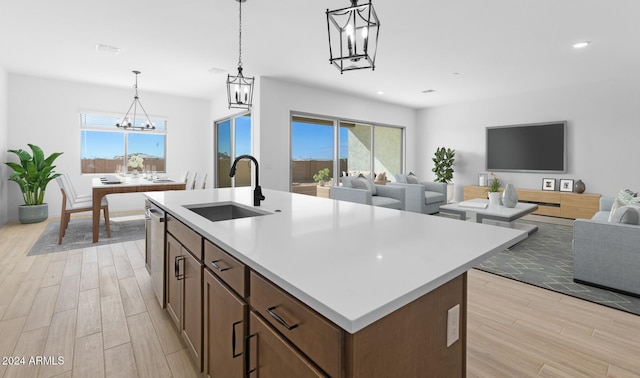 kitchen featuring light countertops, a chandelier, dishwasher, wood tiled floor, and a sink