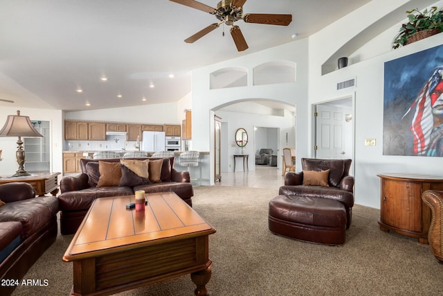 tiled living room with ceiling fan and high vaulted ceiling