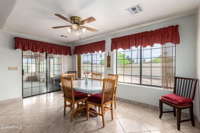 dining space with light tile floors, ceiling fan, and a healthy amount of sunlight