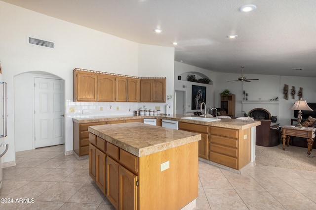 kitchen with backsplash, ceiling fan, a kitchen island with sink, and sink