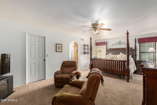 bedroom with ceiling fan, a textured ceiling, light carpet, and multiple windows