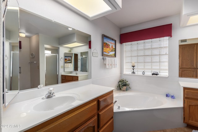 bathroom with shower with separate bathtub and dual bowl vanity