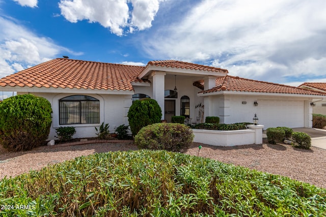 mediterranean / spanish-style home with a garage