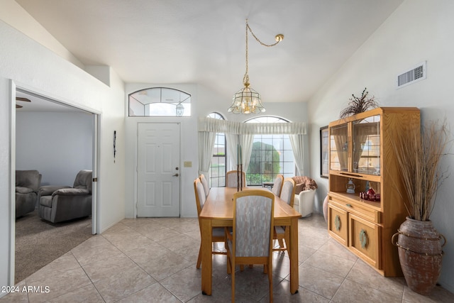 tiled dining area with an inviting chandelier and vaulted ceiling