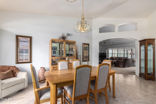 dining room featuring high vaulted ceiling, ceiling fan with notable chandelier, and light tile floors