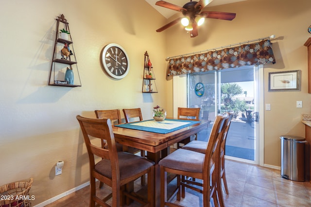 dining room with ceiling fan, tile patterned floors, and lofted ceiling