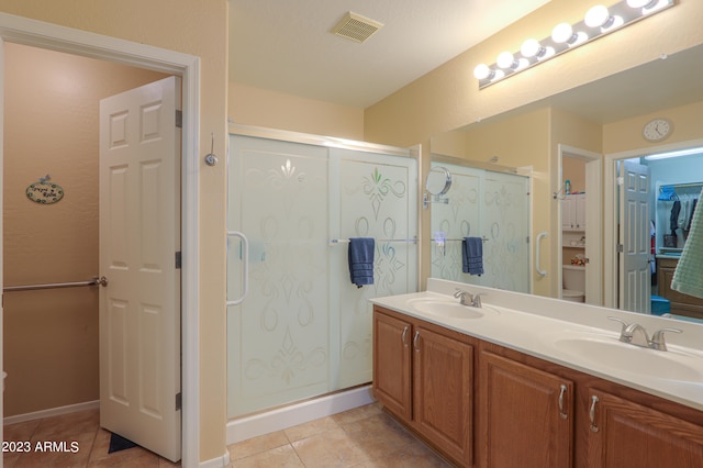 bathroom featuring vanity, a shower with door, and tile patterned flooring