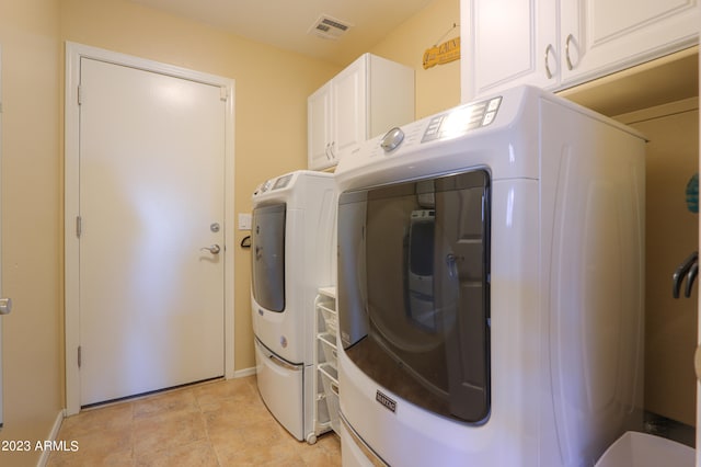 washroom featuring washing machine and dryer and cabinets