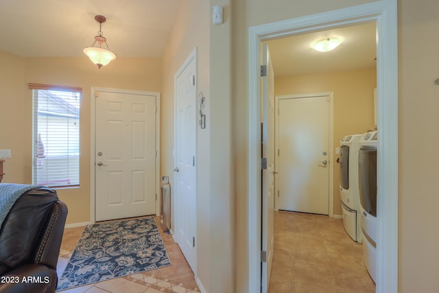 entryway with washer and dryer, light tile patterned floors, and lofted ceiling