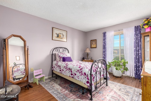 bedroom featuring hardwood / wood-style floors and a textured ceiling