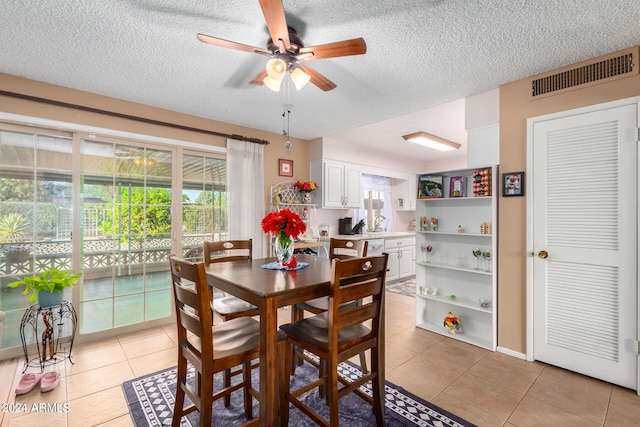 dining area featuring light tile patterned flooring, a textured ceiling, and ceiling fan