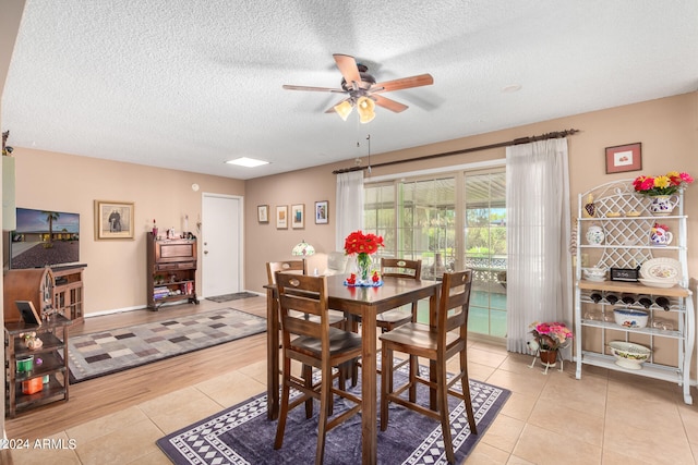 dining area featuring ceiling fan, a textured ceiling, and light wood-type flooring