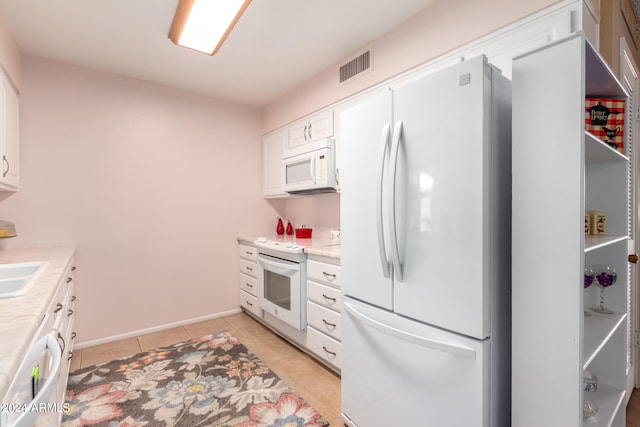 kitchen featuring white cabinetry, sink, light tile patterned floors, and white appliances