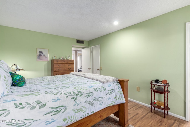 bedroom featuring hardwood / wood-style floors and a textured ceiling