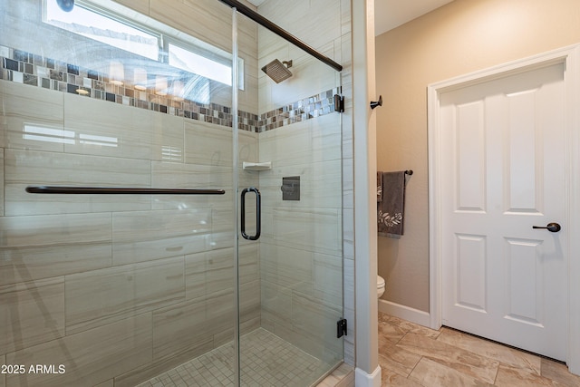 bathroom with toilet and a shower with shower door