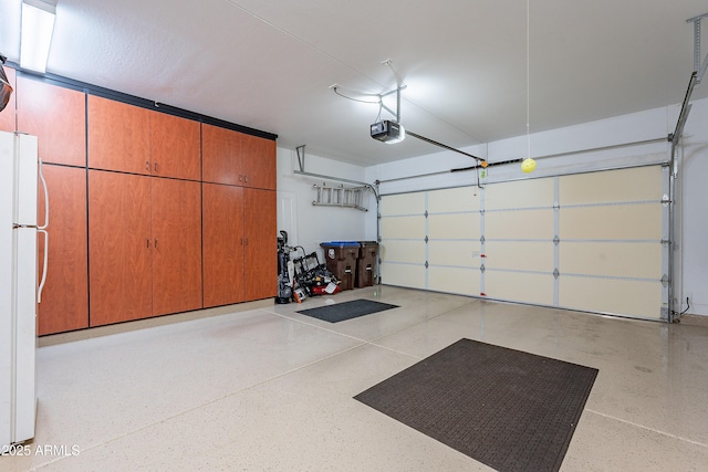 garage featuring white fridge and a garage door opener