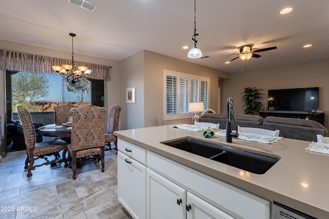 kitchen with a healthy amount of sunlight, white cabinetry, sink, and hanging light fixtures