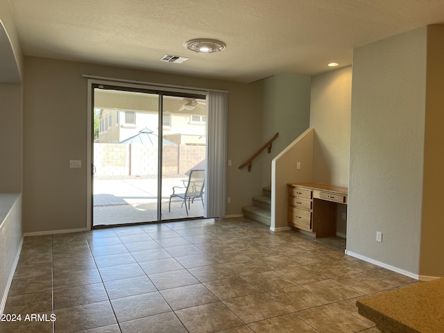 unfurnished living room featuring light tile patterned flooring and a textured ceiling