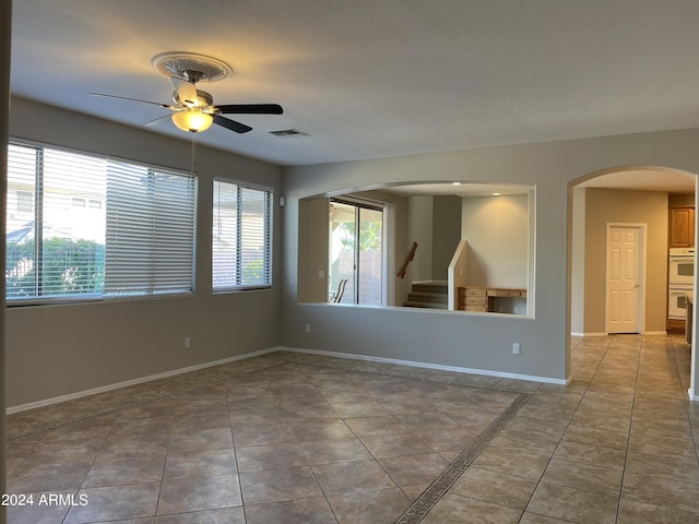 empty room with tile patterned floors and ceiling fan