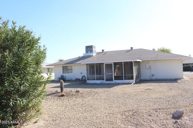 rear view of house with a sunroom and central AC