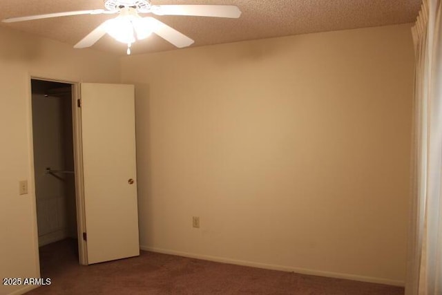 unfurnished bedroom featuring carpet floors, a spacious closet, ceiling fan, a textured ceiling, and a closet