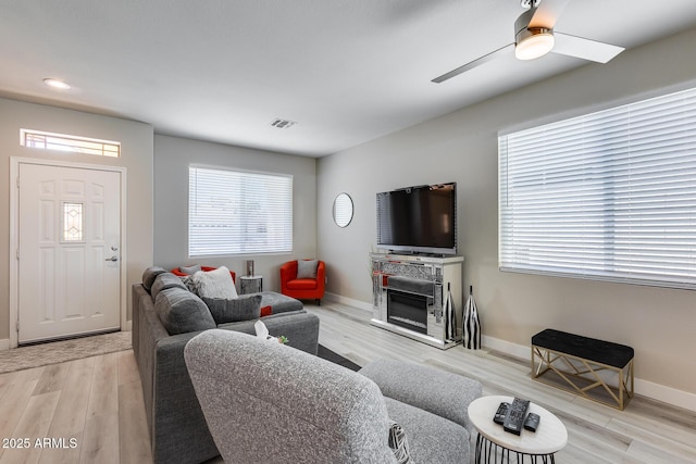 living room with ceiling fan, light wood finished floors, baseboards, visible vents, and recessed lighting