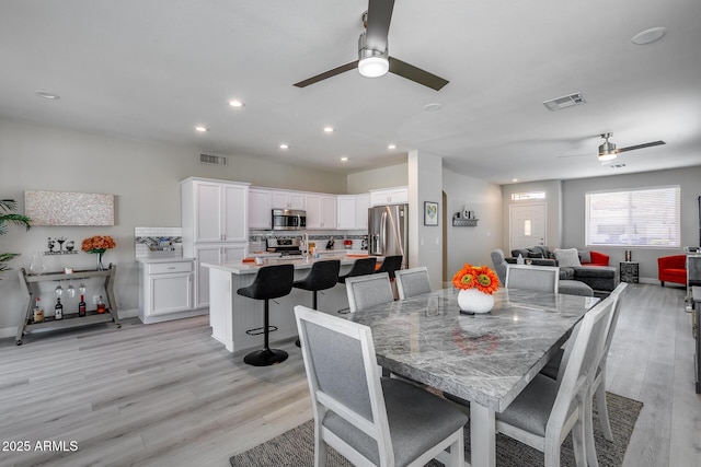 dining area featuring a ceiling fan, visible vents, and light wood-style flooring